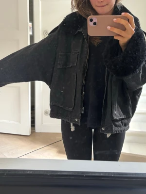 Oversized svart jeansjacka med fuskpäls - Säljer en svart jeansjacka med pälsdetalj. Pälsen går att ta av lätt och sen också sätta på lätt. Är i storlek S/M
