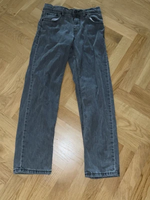 Grå  jeans från Levi's Loose Taper strl 152cm - Snygga grå jeans från Levi's med rak passform och klassiska fem fickor. Jeansen har en diskret tvättad look och Levi's ikoniska läderpatch bak i midjan. Tillverkade i slitstark denim med svarta sömmar och normal midja. Hör av er vid frågor.😀