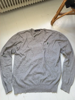 V- ringad tröja från Ralph Lauren - Säljer denna grå v-ringade tröjan från RL, den är i fint skick vill jag ändå säga. Hör av dig vid frågor!