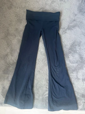 Svarta bootcut leggings  - Säljer ett par svarta leggings med bootcut-ben och bred, hög midja. Mjukt och stretchigt material som sitter skönt på kroppen. Perfekta för en avslappnad och trendig look.
