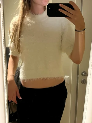Vit fluffig stickad kortärmad tröja - Säljer en vit, fluffig stickad tröja från Carin Wester. Tröjan har liten sminkfläck vid halskragen. Skriv vid funderingar. Priset kan diskuteras.✨💕