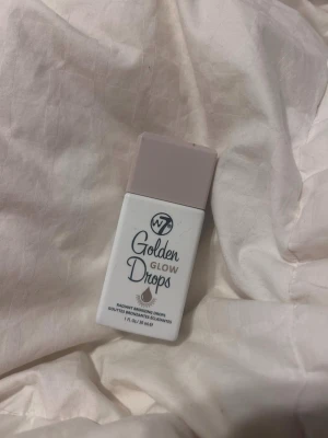 W7 Golden Glow Drops bronzer - Golden Glow Drops från W7 är flytande bronzerdroppar i en smidig vit plastflaska med ljuslila lock. Ger en fräsch, solkysst look med glow. Perfekt att blanda i foundation eller använda direkt på huden för extra lyster. Använt 2 gånger.