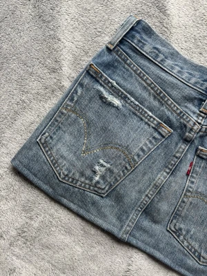 Vintage lowwaist Levis kjol - Vintage lowwaist jeanskjol från Levis. Jättefina diamanter på fickorna och coola slitningar. I toppskick! Jag har lagt upp den så bara att sprätta upp om man vill ha den längre. Jag skulle säga storlek xs. Hör av er för fler bilder eller frågor❤️
