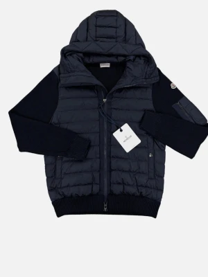 Mörkblå pufferjacka från Moncler - Snygg mörkblå pufferjacka från Moncler med quiltad front och huva. Jackan har stickade ärmar och muddar, dragkedja framtill och en liten ficka med dragkedja på ena ärmen. Perfekt för dig som vill ha både stil och funktion.