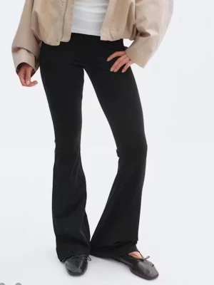 Svarta bootcut leggings - Snygga svarta leggings med bootcut-modell och hög midja. Stretchigt material som sitter tajt över låren och släpper ut nedtill för en trendig siluett. Perfekta att matcha med både sneakers och ballerinas.