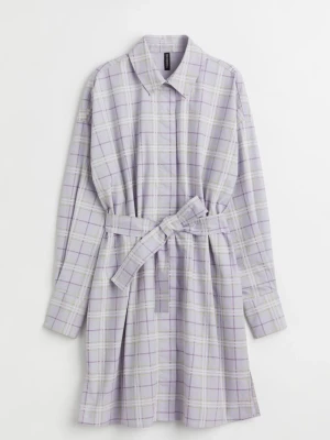 Ljuslila rutig skjortklänning med bälte från H&M, stl M ny oanvänd  - Säljer en ljuslila skjortklänning med rutigt mönster i vitt och ljusgrönt. Klänningen har lång ärm, klassisk krage, knappar framtill och ett matchande bälte i midjan. Perfekt för dig som gillar en avslappnad men ändå stilsäker look. Stl M