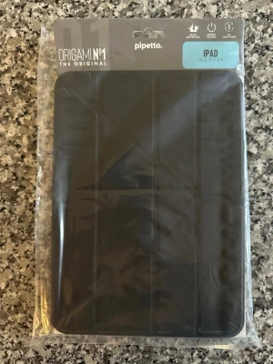 Origami iPad fodral svart Pipetto - Snyggt svart Origami-fodral från Pipetto till iPad A16 & 10th Gen. Fodralet har 5-i-1 ställfunktioner, automatisk sleep/wake och skyddar mot fall upp till 1 meter. Tillverkat i tåligt material och har vikbar framsida för flexibel användning.