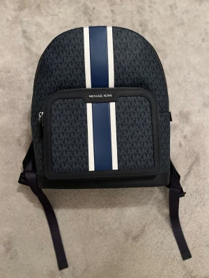 Michael Kors ryggsäck  - Snygg blå ryggsäck från Michael Kors med vita och mörkblå ränder framtill. Väskan köptes för 3000kr säls för 1900kr först till kvarn🔥🔥