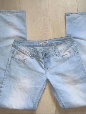 Ljusblå bootcut jeans från Replay - Säljer ett par supersnygga ljusblå bootcut jeans från Royal Jeans med klassisk femficksmodell. Jeansen har en snygg tvättad look, låg midja och metallknapp framtill. Lågmidjade. Midjemått 41 cm ungefär💕