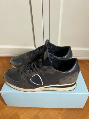 Philippe Model Trpx sneaker strl 44 - Säljer dessa snygga Philippe Model skor i st 44 marinblå. Skorna kan användas bra året runt och funkar bäst om man ska vandra i berg eller gå långa sträckor. De är även utmärkta under vinter och sen höst. Skorna har används ett fåtal gånger och är som nya. Nypris 3300kr, mitt pris 1299kr! Hör gärna av er vid frågor eller funderingar!