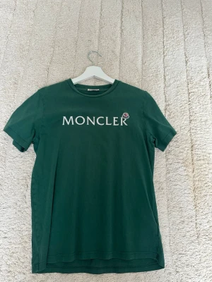Grön Moncler t-shirt  - Snygg grön t-shirt från Moncler med klassisk logga tryckt på bröstet. Tillverkad i mjuk bomull. Köpt på Nk i Stockholm 