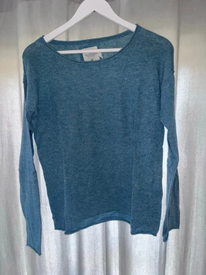 Blå stickad tröja från H&M L.O.G.G. - Mysig blå stickad tröja från H&M:s L.O.G.G.-kollektion. Tröjan har rund halsringning, långa ärmar och är tillverkad i ett mjukt, tunt stickat material. Perfekt för lager på lager och enkel att matcha med olika outfits.