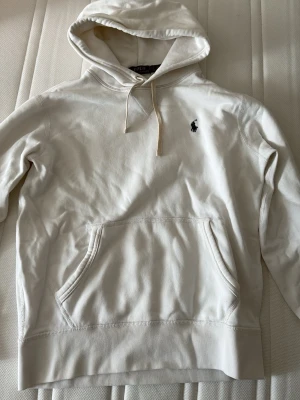 Vit Ralph Lauren hoodie - Snygg vit hoodie från Polo Ralph Lauren med  huva och snören. Tillverkad i mjukt bomull.  Storlek S!