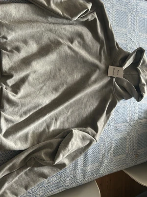 Grå hoodie  - Snygg grå hoodie  med klassisk huva och långa ärmar. Tillverkad i mjukt bomullsmaterial. Köpt på blocket men tyvärr för stor