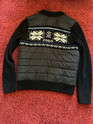 Ralph Lauren Cardigan  - Snygg svart cardiganjacka från Polo med quiltad framsida och rygg, stickade ärmar och ribbade muddar. Perfekt till hösten eller kyliga sommarkvällar. Passar ca 165-175cm