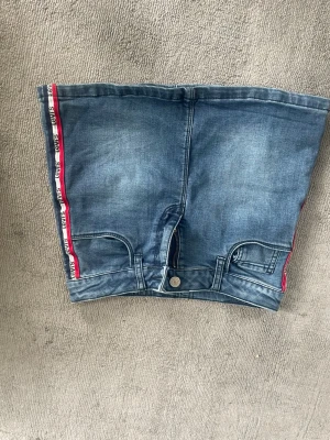 Jeanskjol med röda sidor och fickor - Cool och lite kort Jens kjol från Levis, Älskart, Cjut och ass skön faktiskt 