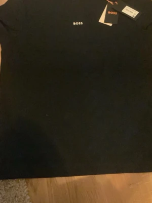 BOSS T-shirt Herr M – Ny med taggar (Original - Säljer en helt ny och oanvänd BOSS T-shirt i storlek M. Originaltaggarna sitter kvar.  * ✅ Märke: BOSS * ✅ Modell: TChup * ✅ Storlek: M * ✅ Färg: Svart * ✅ Skick: Ny med taggar * ✅ Material: 96 % bomull, 4 % elastan
