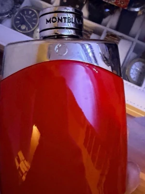 Montblanc röd parfym 100 ml - Montblanc parfymflaska i en snygg röd färg med silverfärgat lock och detaljer. Flaskan rymmer 100 ml Eau de Parfum och har en modern, stilren design som sticker ut i badrumshyllan.
