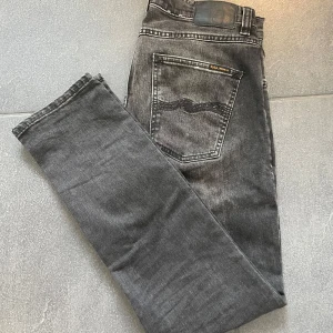 Nudie Jeans - Säljer ett par grå jeans från Nudie Jeans. Jeansen har en diskret tvättad look och raka ben.  Storlek: 31/30.                                                                   Skick: Bra inga  defekter alls 