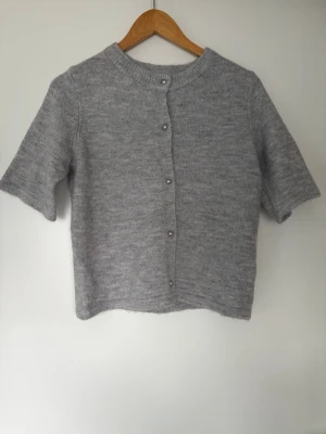 Stickad T-shirt - Fin stickad T-shirt med pärlliknande vita knappar. 