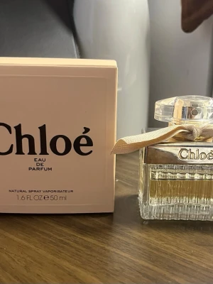 Chloé EDP 50 ml - Säljer den klassiska Chloé Eau de Parfum (50 ml). En underbar, feminin och elegant doft i kategorin blommig/orientalisk-blommig med härliga noter av pion, litchi, fresia och ros på en varm bas av bärnsten och ceder. Parfymen är använd och kvarvarande mängd syns på bilderna. Kan finnas vissa spår/fläckar på flaskan. Har förvarats mörkt och svalt. Originalkartong medföljer. 