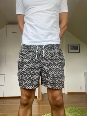 Svarta mönstrade badbyxor från Bläck - Svarta mönstrade badbyxor från Bläck. Strl S. Inga defekter. Modellen är 178 cm och väger 77 kg. Hör gärna av dig vid frågor!