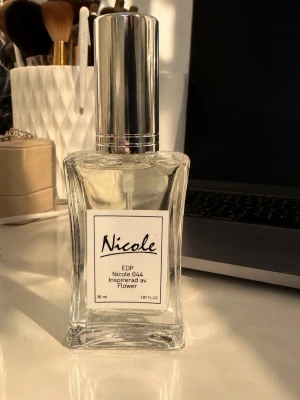 Nicole 044 Eau de Parfum 30 ml - Fräsch parfym från Nicole, inspirerad av Flower. Kommer i en elegant, genomskinlig glasflaska med silverfärgad spraykork. Flaskan rymmer 30 ml och har en stilren etikett framtill. Perfekt för dig som gillar blommiga dofter.