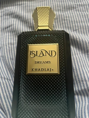 Island Dreams parfym från Khadlaj -  Säljer min Khadlaj Island Dreams Extrait de Parfum (100 ml). Liknar Louis Vuitton Symphony. * Extrait de Parfum * Ca. 95 % kvar (se bilder för exakt nivå) * Originalflaska i mycket fint skick * Förvarad svalt och mörkt       Har ej orginalbox 