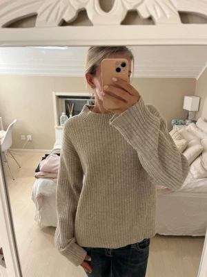 Ribbstickad tröja - Mysig beige ribbstickad tröja med rund hals och långa ärmar. Tröjan har en avslappnad passform och är tillverkad i ett mjukt material som passar perfekt för kyligare dagar💗