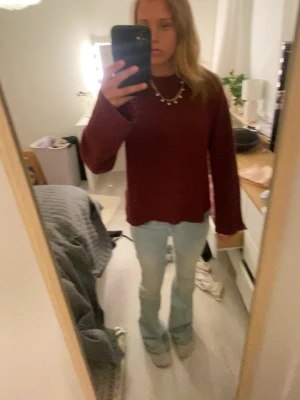 Vinröd stickad tröja från Kappahl - Mysig vinröd stickad tröja från Kappahl med rund halsringning och ribbade muddar vid ärmslut och nederkant. Tröjan har en rak passform och är perfekt för kyligare dagar. Materialet känns mjukt och behagligt mot huden💗