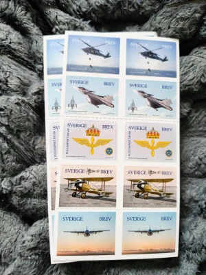 Frimärken Flygvapnet 100 år Sverige - Säljer två ark med svenska frimärken från Postnord, tema Flygvapnet 100 år. Motiven visar olika flygplan och symboler från det svenska flygvapnet. Varje ark innehåller 10 frimärken för brev inom Sverige. Perfekt för samlare eller brevskrivare.