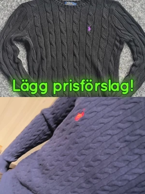 Två stickade tröjor från Ralph Lauren  - Kabelstickad tröja i mörkblått från Polo Ralph Lauren med klassisk röd logga broderad på bröstet. Tröjan har rund halsringning och ribbade muddar vid ärmslut och nederkant. Tillverkad i mjukt material för en skön passform.