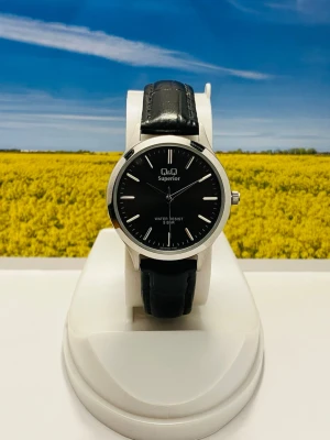 Q&Q Superior svart klocka - Stilren klocka från Q&Q Superior med svart urtavla och silverfärgat boett. Klockan har ett klassiskt svart läderband med krokodilpräglad yta och minimalistisk design. Perfekt accessoar för dig som gillar enkel och tidlös stil. 
