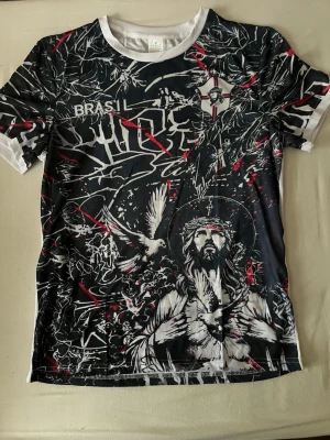 Svart och vit t-shirt | fotbolls designer tröja - Unik t-shirt med svart, vit och röda grafiska mönster och tryck av Jesus och duvor framtill. Finns i small och en till i medium, köp 2 för 799!