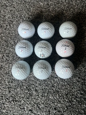 Nio vita Titleist golfbollar - Säljer ett set med nio vita golfbollar från Titleist. Bollarna har olika siffror tryckta på sig och klassisk dimple-design för bra flyg och känsla. Perfekt för dig som vill fylla på golfbagen inför säsongen. KAN DISKUTERA PRIS