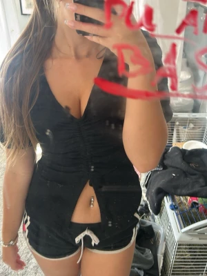 Svart v-ringad topp med puffärm - Snygg svart topp med v-ringning och puffärmar. Toppen har en smickrande snörning framtill som ger en cool detalj och en liten slits nedtill. Perfekt till jeans eller kjol för en party look!💕