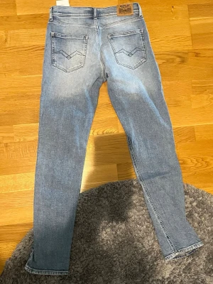 Replay jeans - Ljusblå Replay jeans i storlek 14 år. Passar 164 cm. Är passform slimfit. Lappen har lossnat pyttelite där bak (se bild)