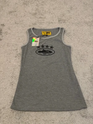Corteiz 4Starz Alcatraz Tank Top Grå - Corteiz 4Starz Alcatraz linne i grått. Våffelstickat/ribbat material med 4Starz Alcatraz-grafik på framsidan. Helt ny och aldrig använd, med originaltags kvar. Storlek enligt etiketten. Rent och i perfekt skick.