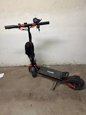 Iscooter ix5s - Elektrisk scooter i svart med röda detaljer och robust ram. Utrustad med dubbla LED-strålkastare fram, digital display på styret och breda däck för extra stabilitet. Scootern har även stöd och laddningsuttag. Perfekt för smidig transport och det som ingår det är laddaren och två nycklar tyvär så ingår inte väskan.