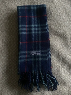 Burberry scarf - Scarfen är äkta Burberry och är i väldigt bra kvalitet. Den är i bra skick, de ända defekterna som finns är små väck som man ser på bild 3 och 4. Den är 136cm lång och 30cm bred. Nypris på den är runt 4500kr