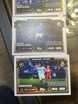 Glittriga fotbollssamlarbilder Topps - Tre glittriga fotbollssamlarbilder från Topps med spelarna Ollie Watkins, Erling Haaland och Endrick. Korten har färgstarka motiv, statistik och klubbmärken. Perfekt för dig som gillar att samla på fotbollskort eller vill byta med vänner.