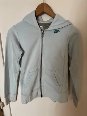 Ljusblå zip hoodie  - Ljusblå hoodie från Nike med dragkedja framtill och två fickor. Klassisk huva och Nike-logga i blått på bröstet🩵