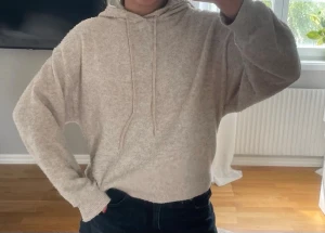 Beige mjuk hoodie med huva - Säljer en beige hoodie med huva och dragsnören. Hoodien är gjord i ett mjukt, fluffigt material och har en avslappnad passform med långa ärmar. Perfekt för dig som gillar en chill och cozy stil.