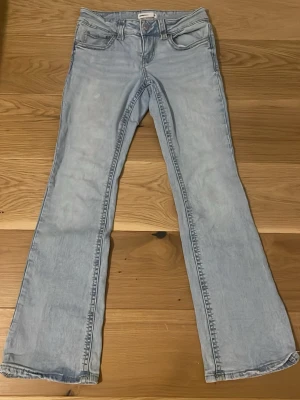 Bootcut jeans (lowwaisted)  - Byxorna har blivit för små så säljer de! Bootcut jeans som är lowwaisted från GinaTricot i ljusblått! Jeansen har fickor bak med knappar! 