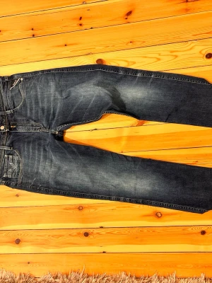 Blå jeans från Replay - Storlek 33/34                                                                  Snygga blå jeans från Replay med klassisk femficksmodell och diskreta slitningar. Jeansen har raka ben och detaljerade sömmar vid fickorna. Tillverkade i denim med en cool tvättad look som passar till det mesta.