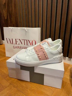 Valentino sneakers - Säljer valentino garavani skor, rockstud 11 med rosa färgade nitar. Väldigt fina och passar till de mesta, sommar skor som passar perfekt nu till sommaren, allt medföljer som på bild. Box och påse. Va snabb me beställningar, alla storlekar finns inne, för frågar är det bara att höra av sig, kika även in våra omdömen🥰