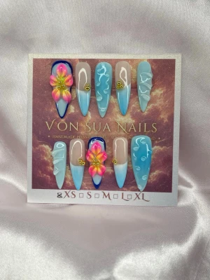 BlueOasis (XS);Medium Stiletto  - Snygga handgjorda press-on naglar i en medium lång stilettoform med blå och nude bas, dekorerade med 3D-blommor i rosa och gult samt 3D drop-detaljer. Några naglar har guldfärgade accenter och en glansig finish. Perfekt för dig som vill ha en unik och kreativ nageldesign.XS: 14 mm, 11 mm, 11,5 mm, 10 mm, 8 mm