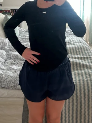 Svart långärmad träningströja Nike - Snygg svart långärmad träningströja från Nike med logga på bröstet. 