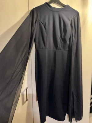 Mörkblå långklänning Zalando  - Elegant mörkblå långklänning med rund halsringning och långa, vida ärmar i ett lätt, transparent tyg. S men funkar även M då tyget är stretch. 