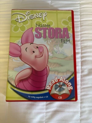 Nasses Stora Film sagobok + CD (2003) - Disney sagobok med Nasse från Nalle Puh på omslaget. Boken är illustrerad i grönt och rosa och innehåller 24 sidor. Medföljer gör en CD med högläsning, röster och musik från filmen. Perfekt för dig som gillar klassiska Disneyberättelser.